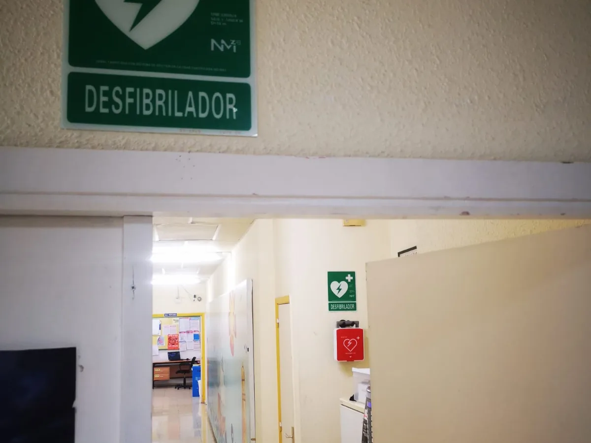 Pasillo del CEIP Xunqueira II con la señal de desfibrilador y el DESA en su vitrina roja