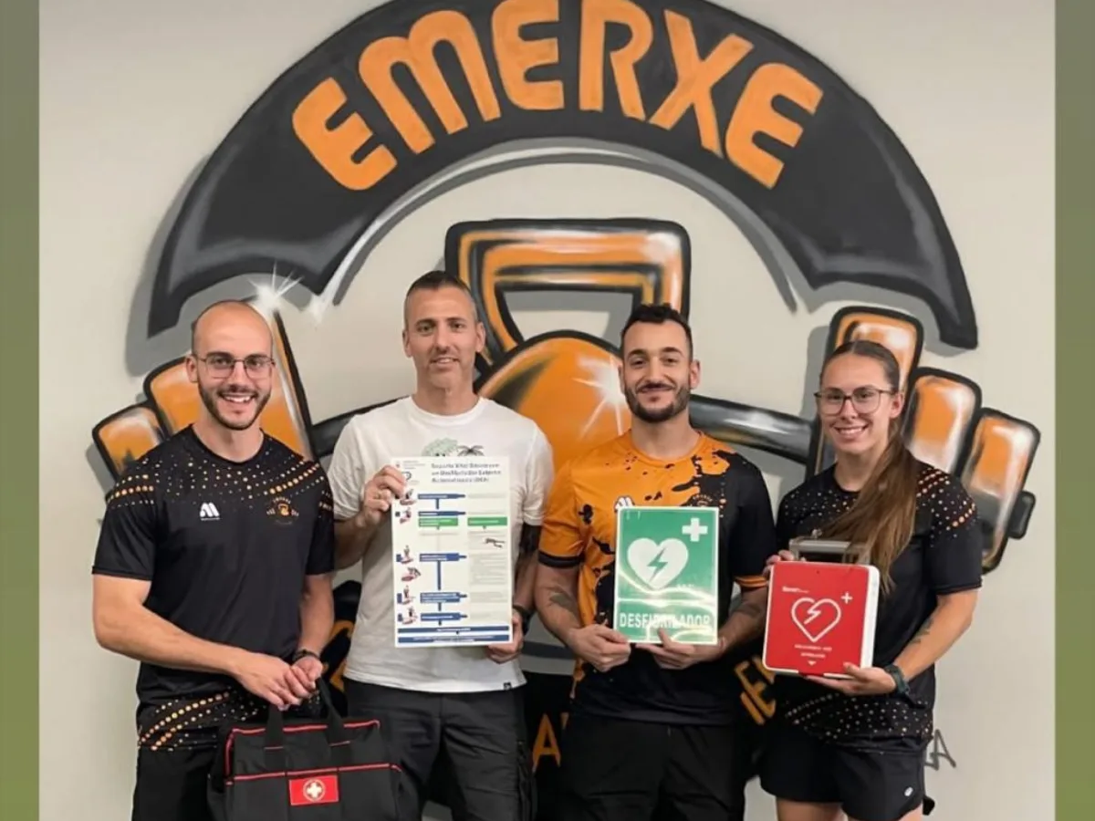 El equipo del gimnasio Emerxe con el cartel de soporte vital básico, la señal de desfibrilador y el DESA
