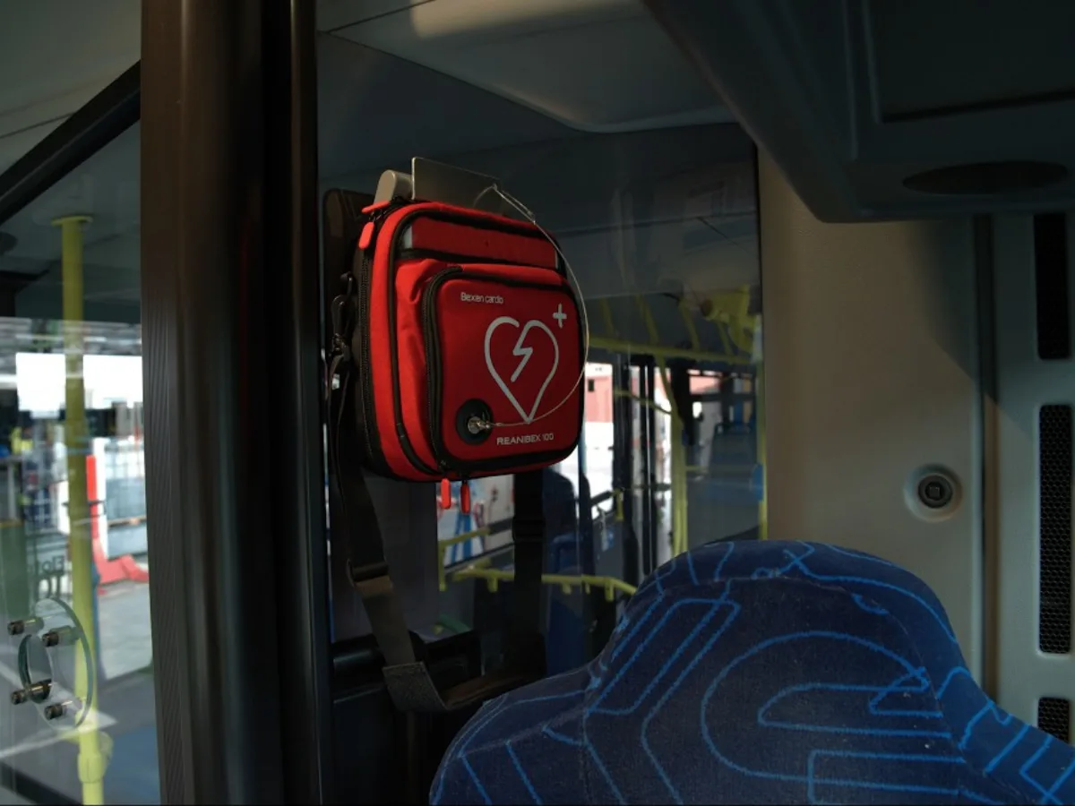 Desfibrilador Reanibex 100 de Bexen Cardio en su funda roja, colgado junto a la puerta de un autobús de EMT Madrid